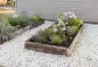 flower beds in front of house with rocks