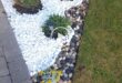 flower beds in front of house with rocks