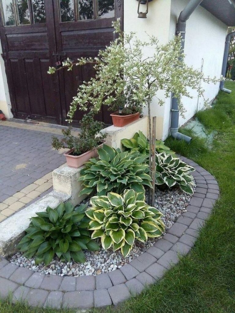 flower beds in front of house with rocks