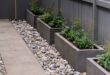 flower beds in front of house with rocks