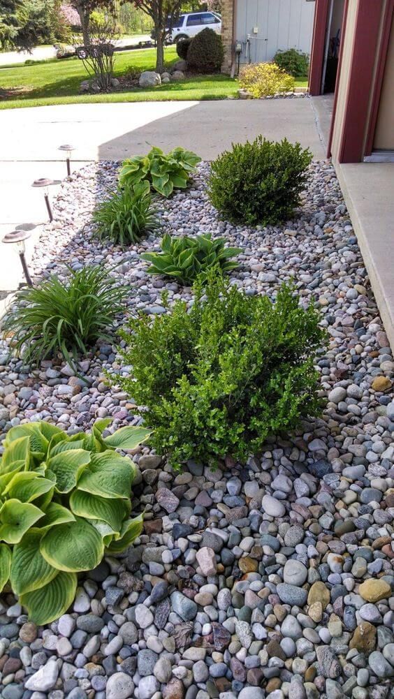 flower beds in front of house with rocks