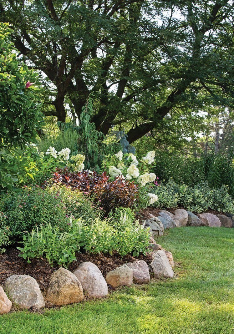 Lush and Tranquil Front Yard Flower Beds with Rocks for Your Home