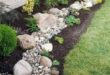 flower beds in front of house with rocks