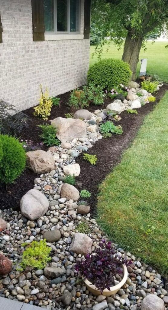 flower beds in front of house with rocks