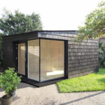 Garden studio has a dark, rough exterior and a light-filled interi