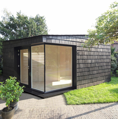 Garden studio has a dark, rough exterior and a light-filled interi