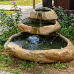 Small garden fountain with flowing water. Beautiful landscape .