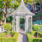 Painted wooden small gazebo with concrete path and flooring in San .