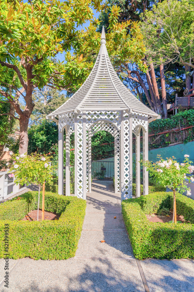 Painted wooden small gazebo with concrete path and flooring in San .